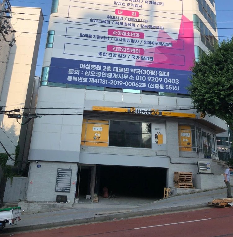 건물 외벽과 지하주차장 입구를 길 건너편에서 바라본 전경입니다.