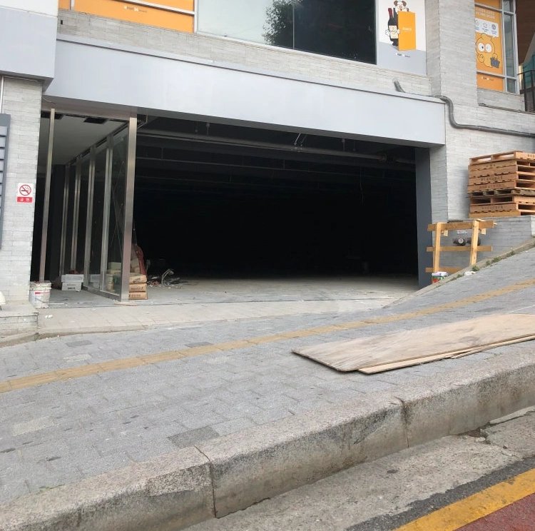 건물 지하주차장으로 이어지는 진입로와 입구 구간을 정비하는 모습입니다.