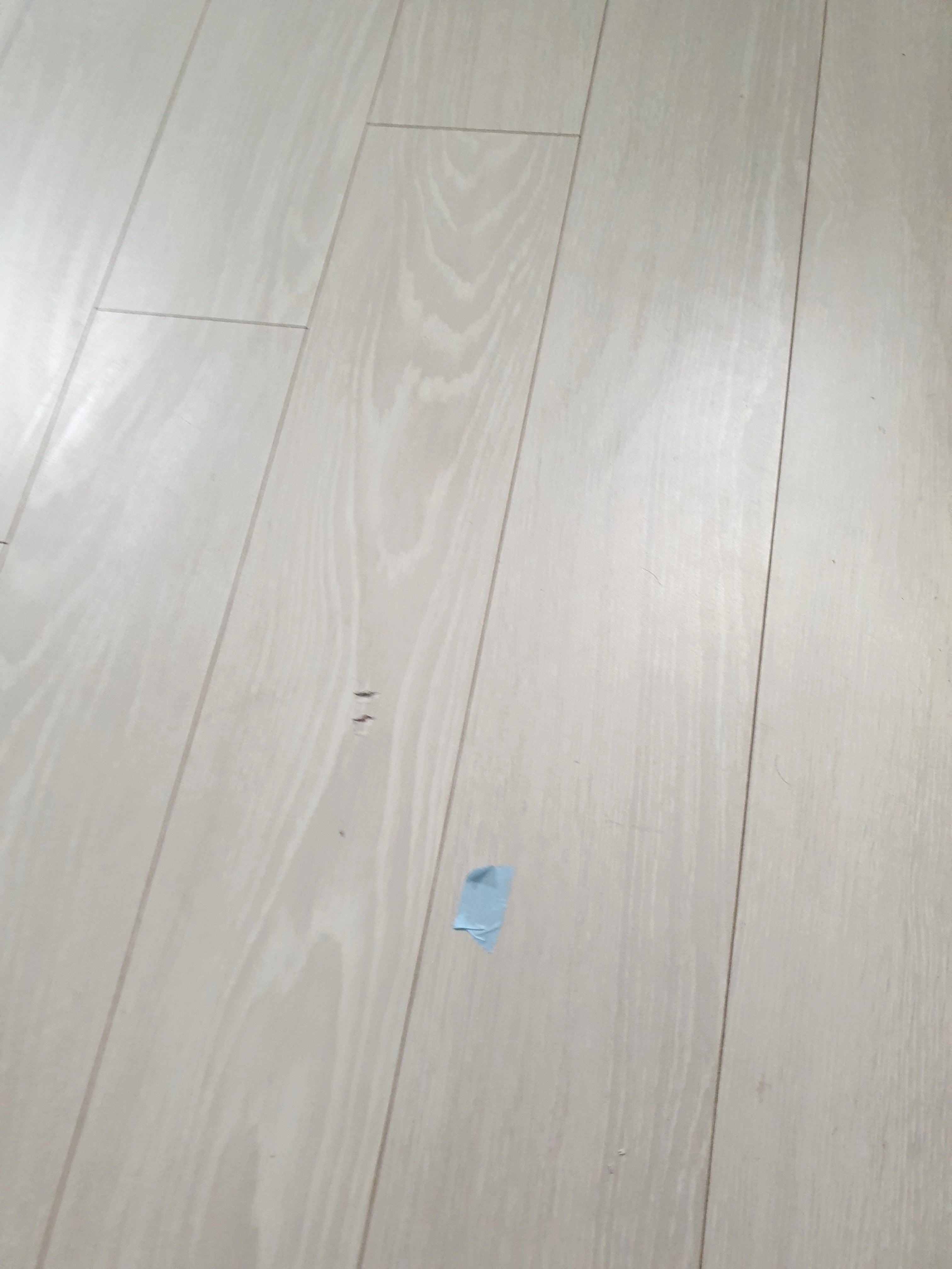 밝은 그레이 톤의 우드패턴 강마루가 클로즈업으로 보이며, 판재 간 이음새가 일정한 간격으로 가지런히 맞춰져 있습니다.