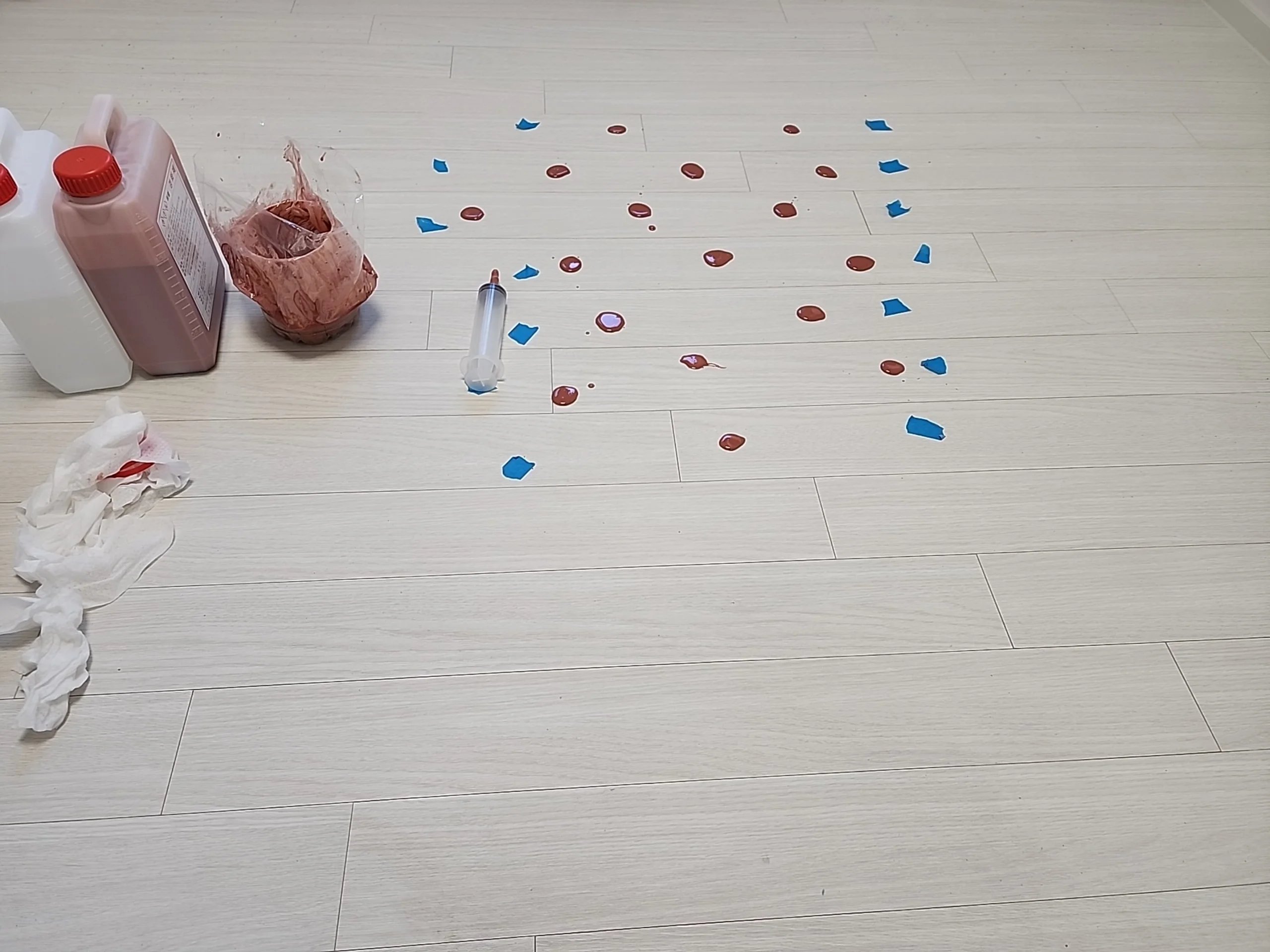 마루 바닥에 보수가 필요한 지점마다 빨간 스티커와 파란 테이프로 위치 표시를 해둔 사진입니다.