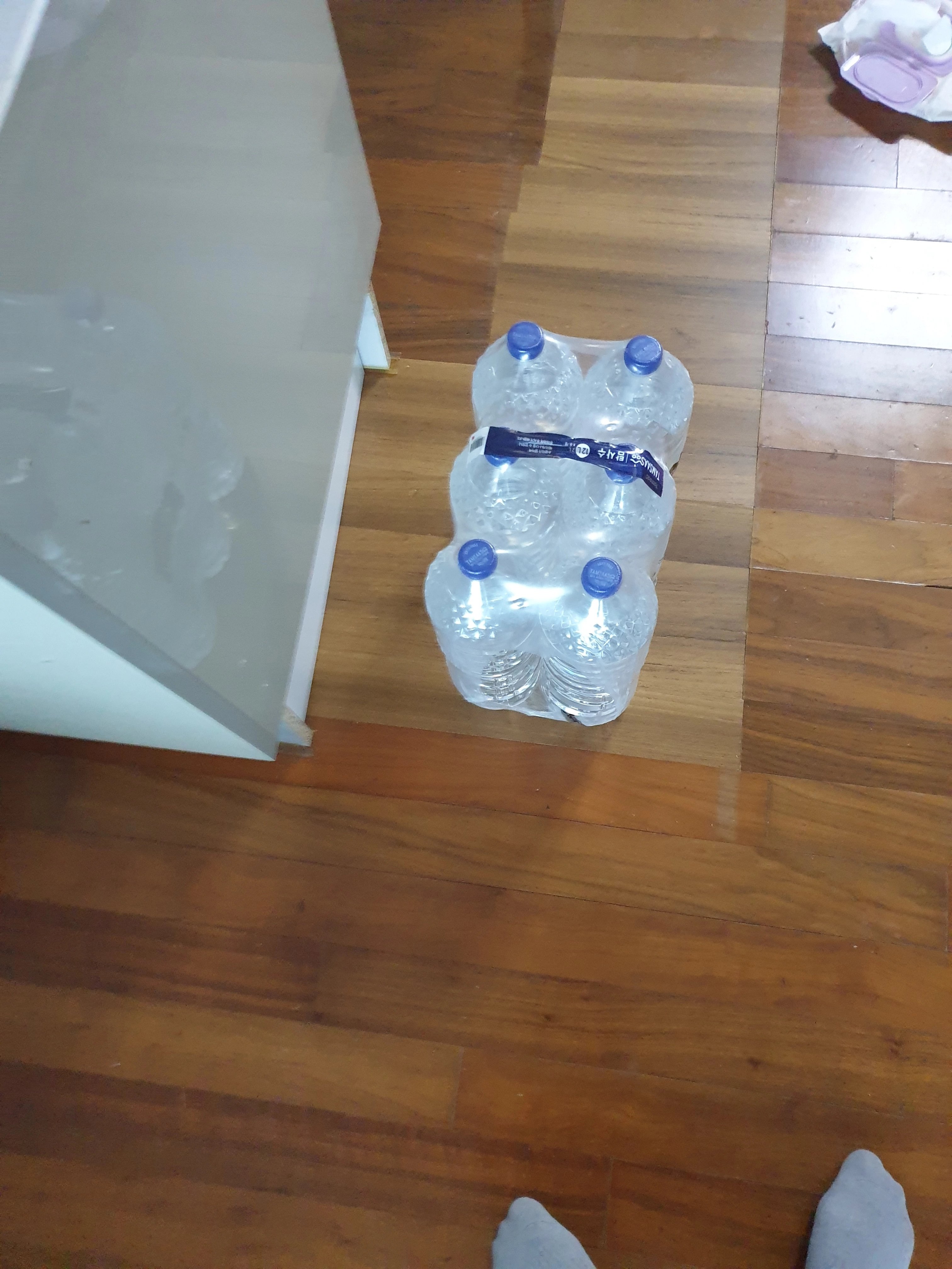 생수병 묶음이 바닥 위에 가지런히 놓여 있는 모습입니다.