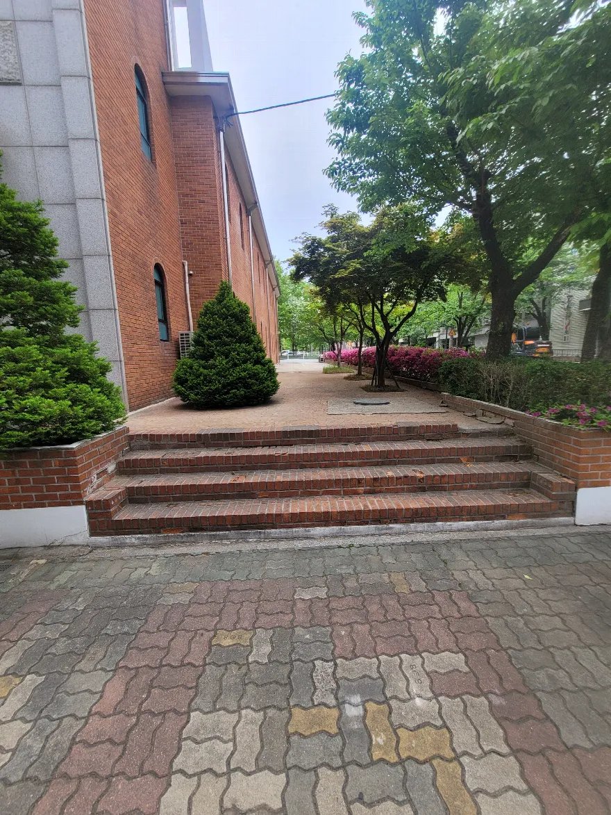 진입 계단과 양옆 화단이 한 세트로 마감된 모습입니다.