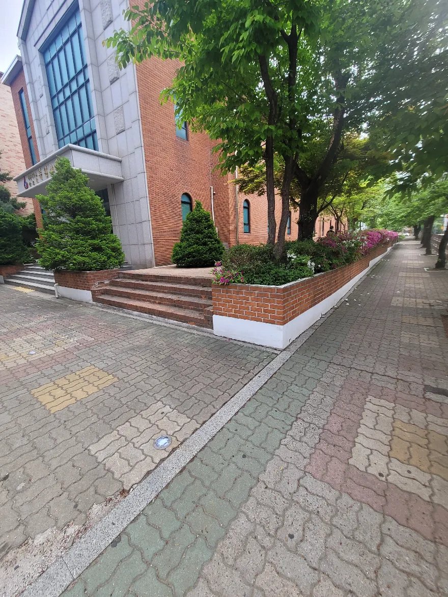 건물 출입 계단을 감싸며 꺾여 도는 화단이 완성된 모습입니다.