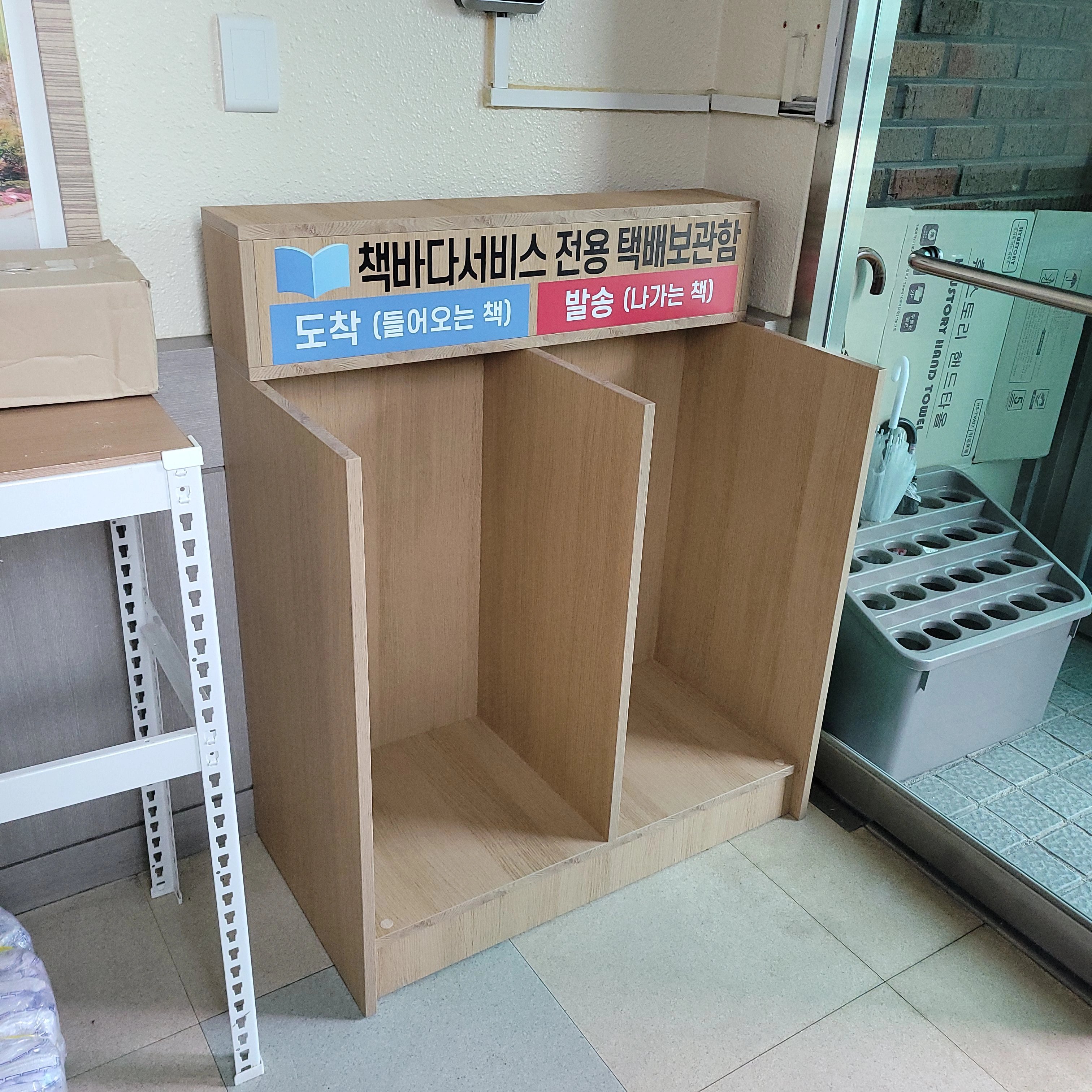 건물 출입구 로비 공간에 맞춤 제작한 목재 수납장을 설치한 모습입니다.