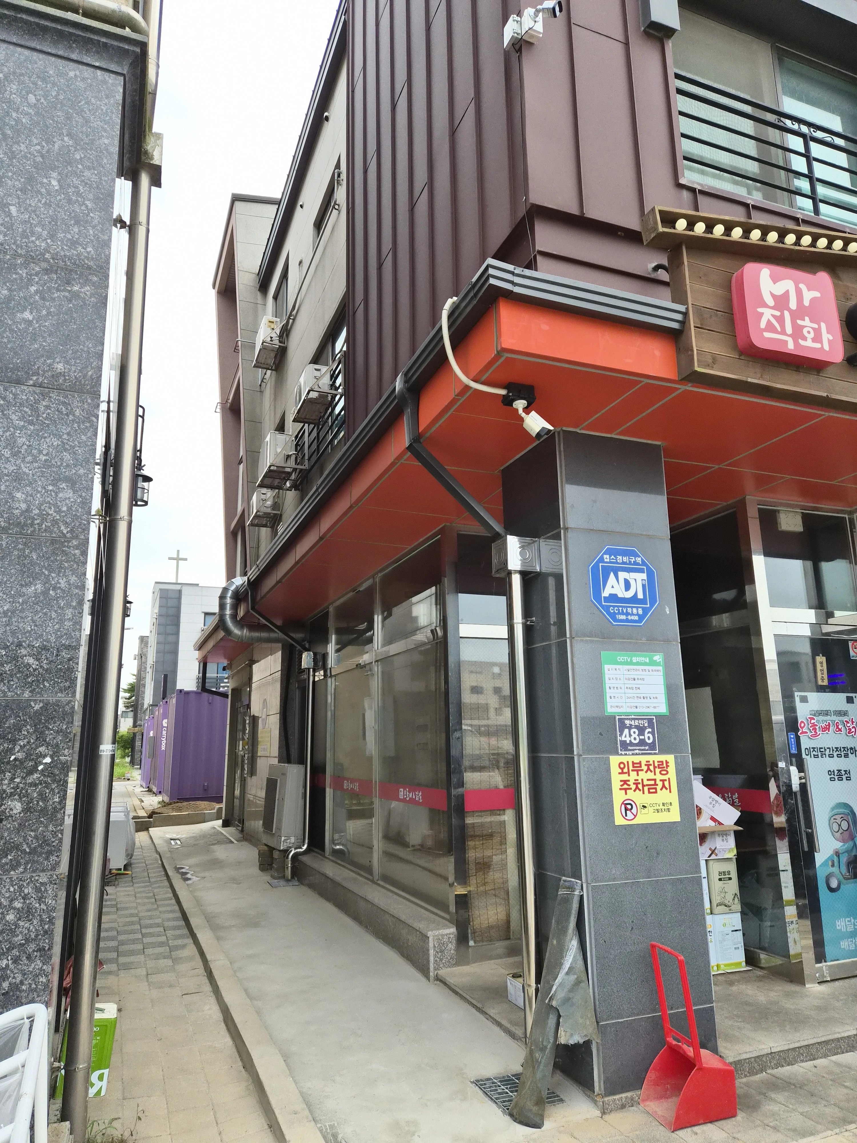 건물 1층 처마 하부를 따라 주황색으로 마감된 빗물받이 라인이 설치된 모습입니다.