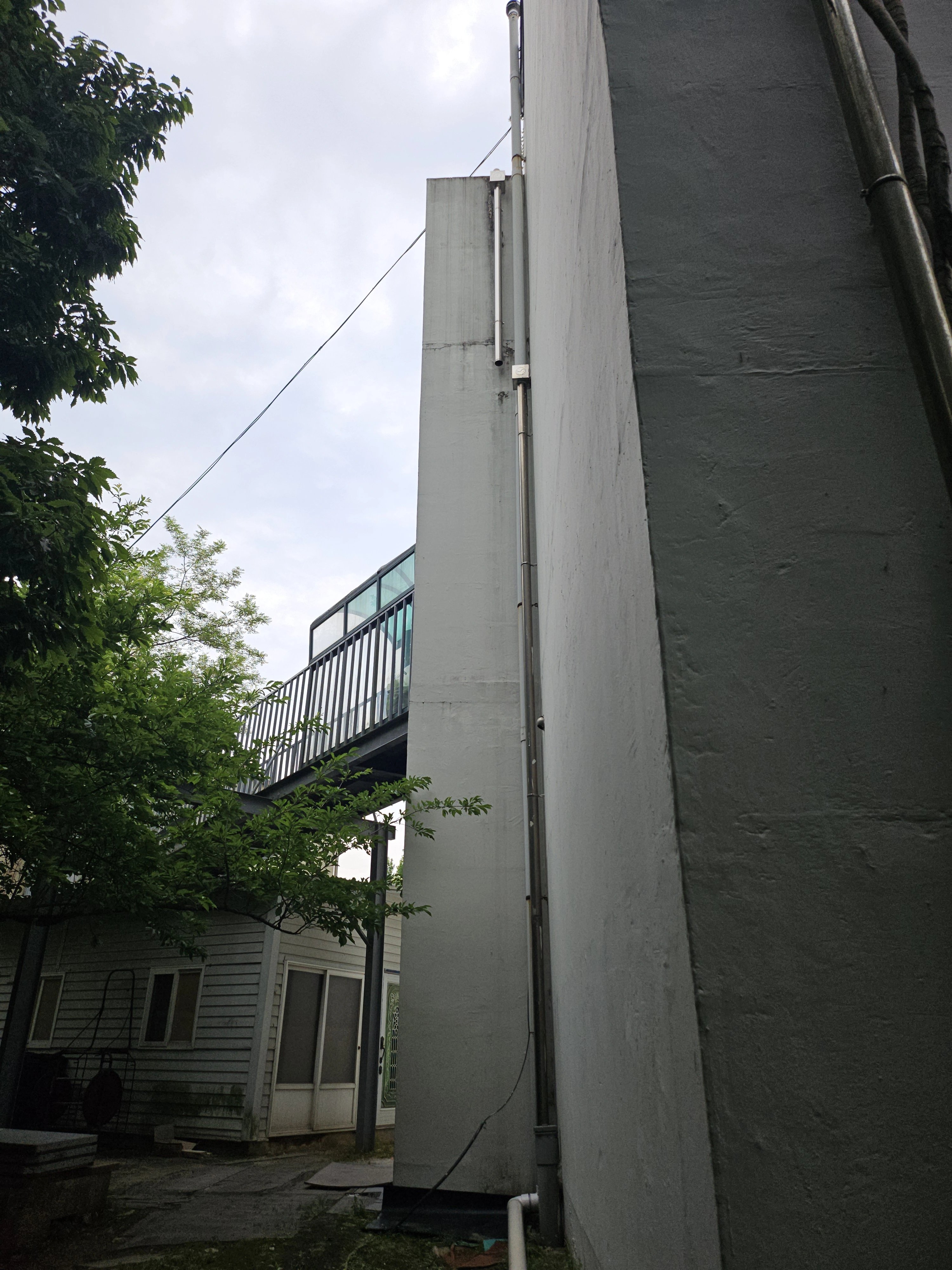 건물 외벽 모서리를 따라 우수관을 세로로 설치한 현장입니다.