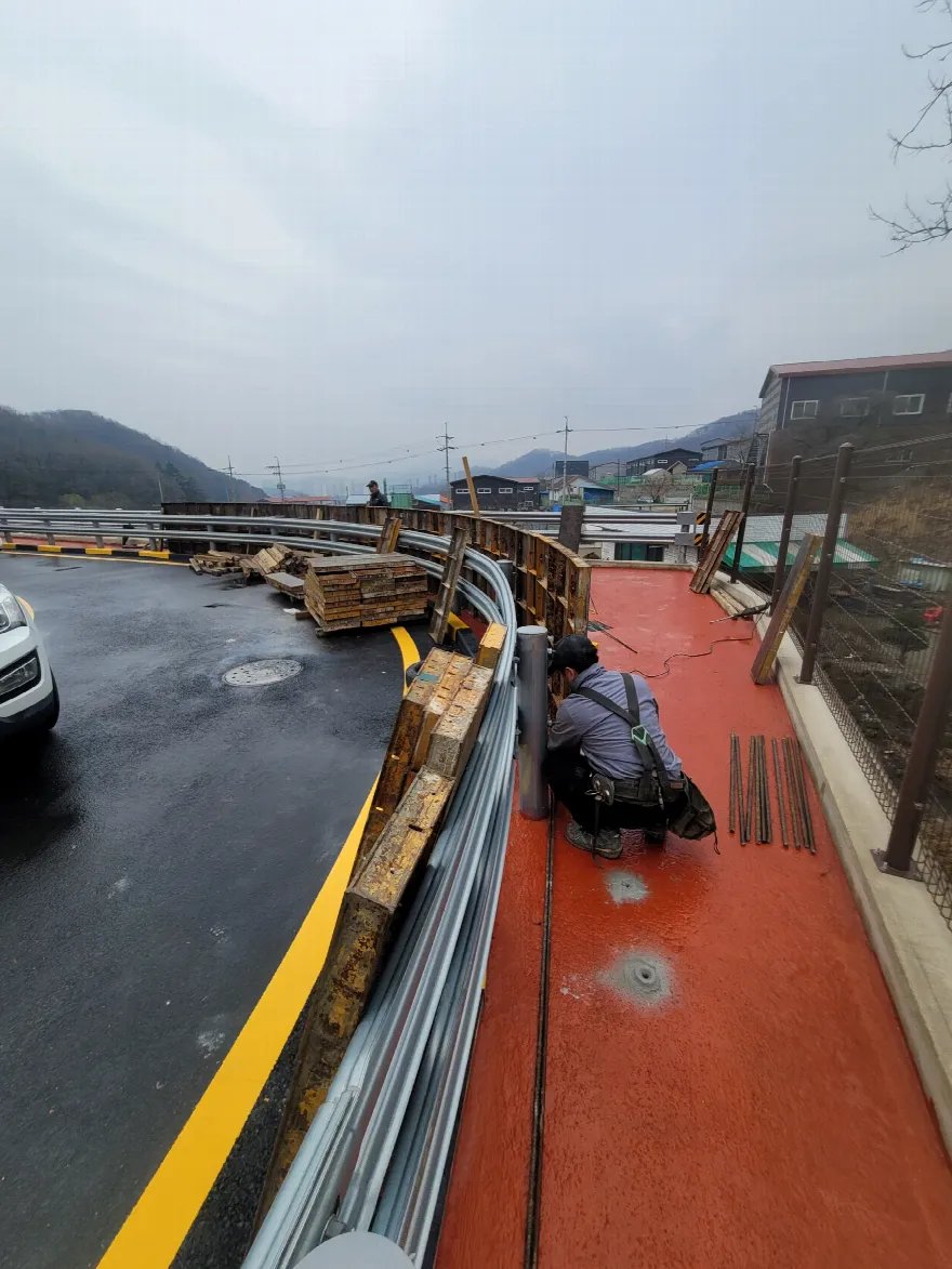곡선 구간 전체를 내려다본 컷으로, 도로를 따라 거푸집이 길게 이어져 세워진 상태입니다.