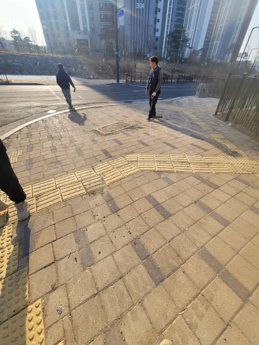 횡단보도 앞 모퉁이 인도가 블록으로 마감된 모습입니다.