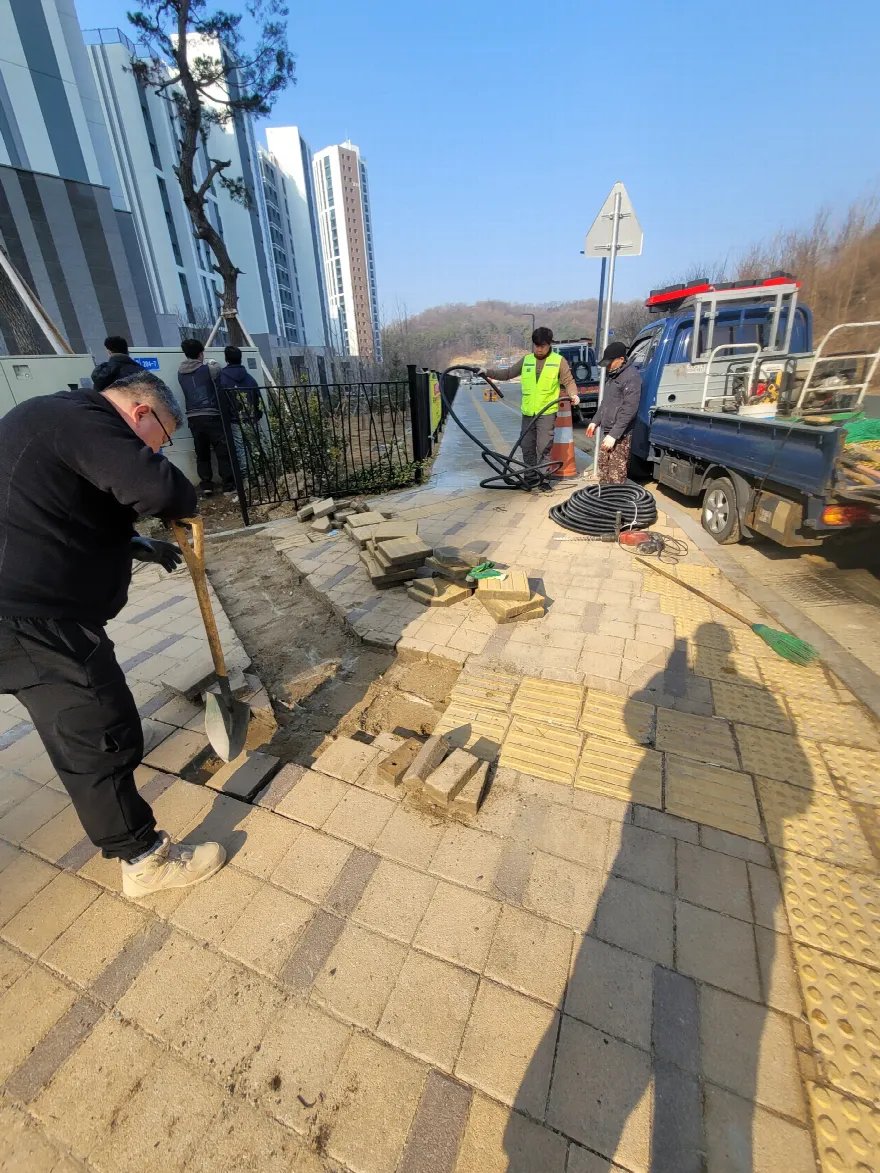 삽으로 블록을 들어내는 철거 작업이 진행 중입니다.