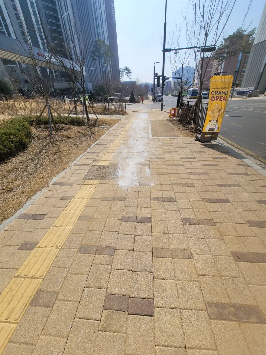 긴 직선 보도 구간의 블록 재시공을 마친 상태로 보입니다.
