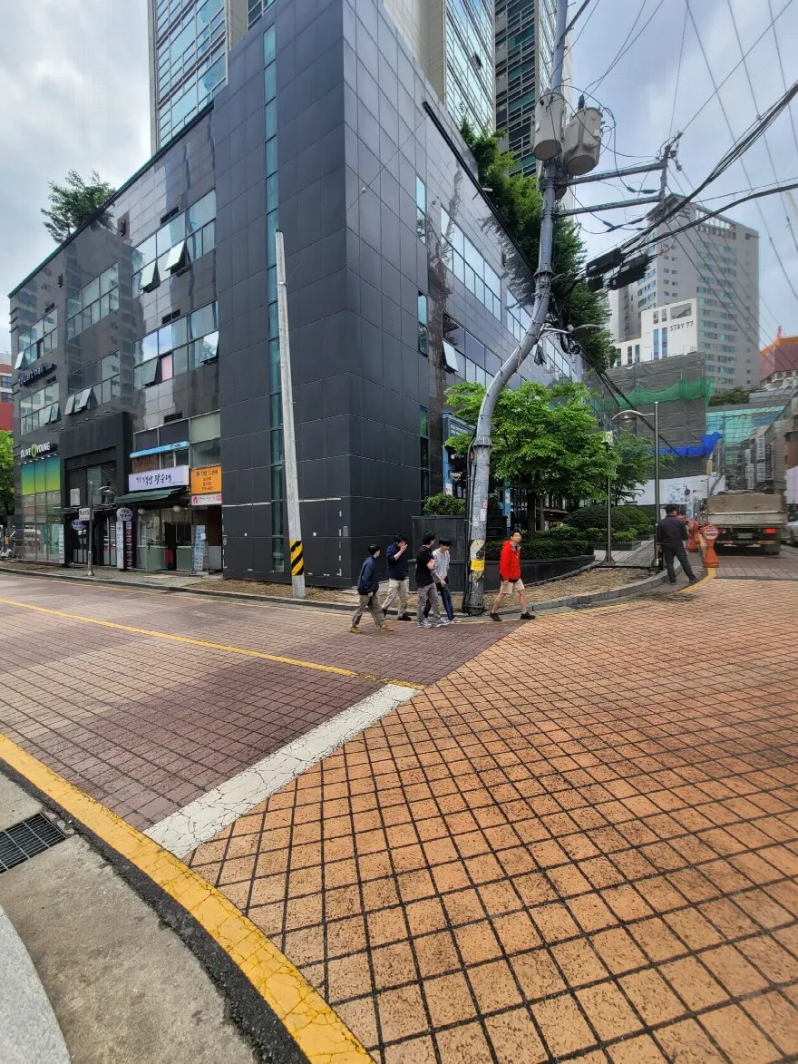 건물 모퉁이 교차로의 블록 포장 차도 부분입니다.