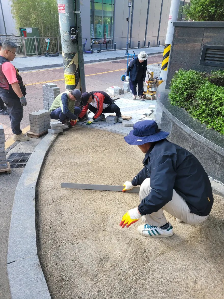 곡선으로 돌아가는 경계석 안쪽에 모래를 포설하고 알루미늄 레벨 바로 밀어 평탄을 잡는 중입니다.