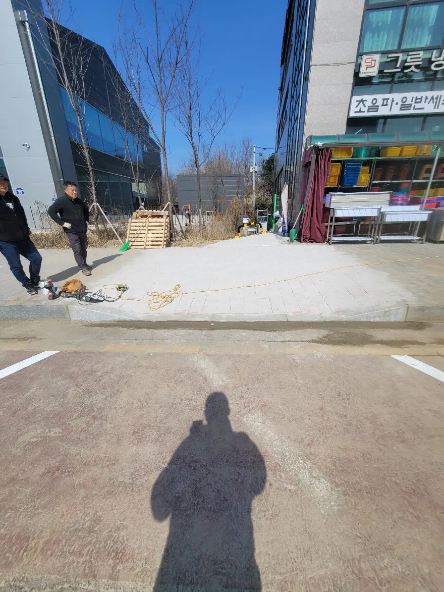 기존 블럭을 걷어낸 인도 구간에 기층 모래를 평탄하게 깔고 노란 실줄을 띄워 기준선을 잡은 모습입니다.