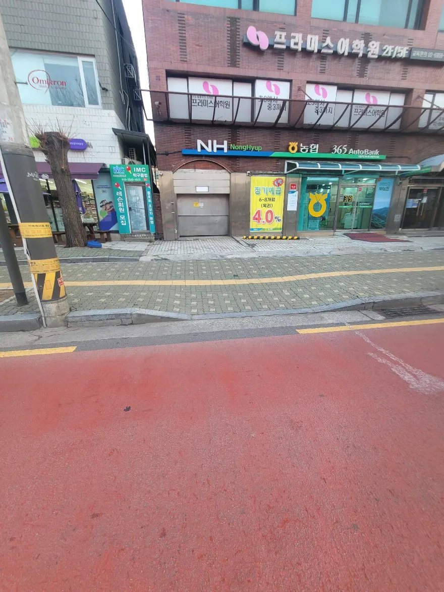 상가 건물 앞 인도와 자전거도로 경계 구간을 도로 쪽에서 살펴본 모습입니다.