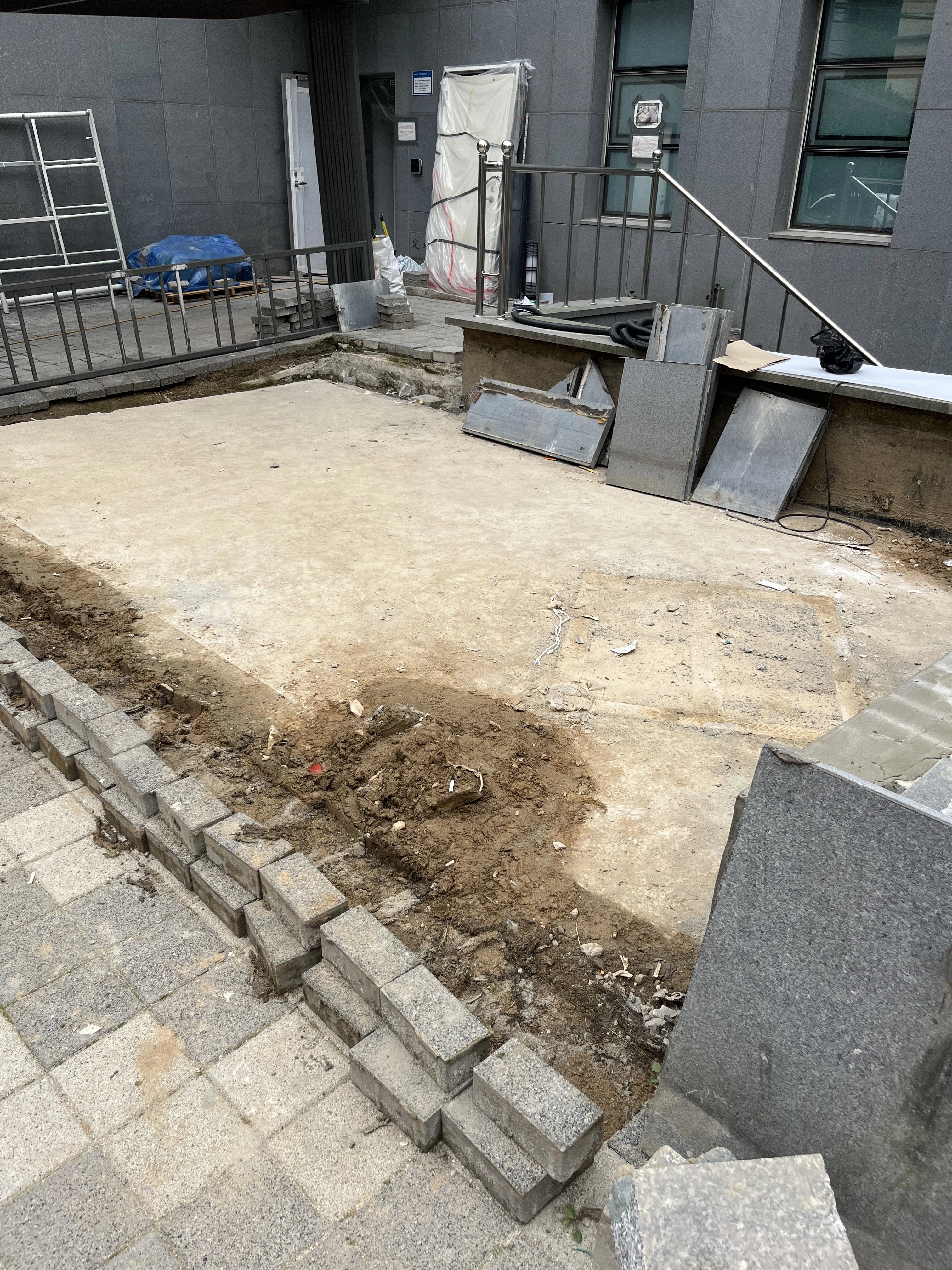 기존 바닥 포장재를 걷어낸 직사각형 구간이 드러나 있고, 가장자리를 따라 회색 경계 블록이 새로 놓여 있다.
