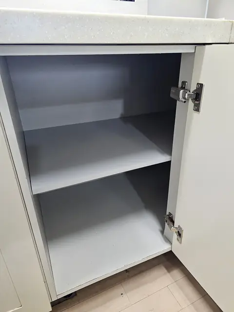 문을 열어 안쪽 선반과 경첩이 보이는 하부장
