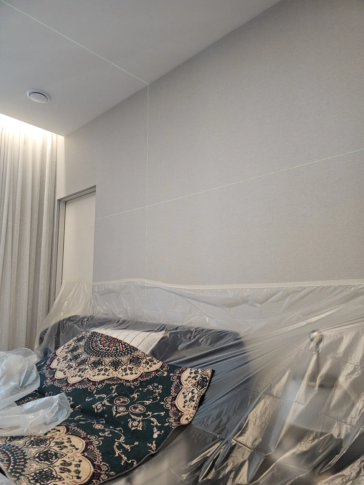 천장·벽체 목공 작업 — 천장과 벽체를 새로 마감하고 가구를 비닐로 덮어 둔 방